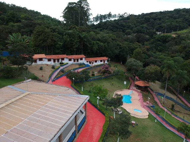 Vista aérea da unidade parceira masculina em Atibaia, com piscina, quiosque e mata ao redor